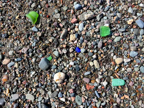 カナダのニューブランズウィック湾沿いのビーチの小石の間に異なる色の海ガラス ストックフォト