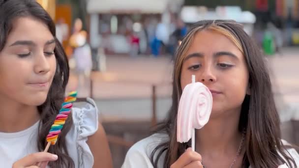 Dos Chicas Jóvenes Comiendo Piruleta Parque Atracciones Ciudad — Vídeo de stock