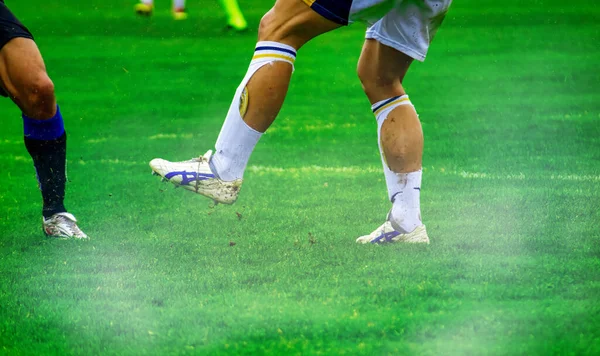 足球运动员在足球场上的腿 — 图库照片