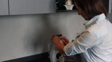 Mutfakta kahve makinesinden bir kupa sıcak filtreli kahve hazırlayan kadın. Sabahları kahvaltı ediyorum..