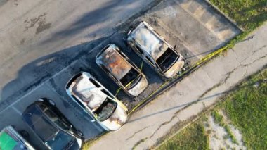 Burned cars in a city parking. Vandalism concept, aerial view drom drone