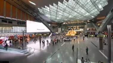 Doha, Katar - Ağustos 2018: Doha Uluslararası Havalimanı 'nda turistler ve dükkanlar.