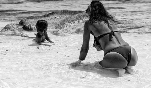 妇女和女儿的后面看法在海水放松 — 图库照片