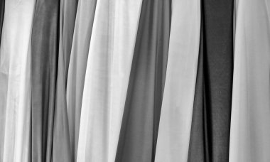 Kumaş dokusuna yakın çekim. Farklı renklerde kumaş örnekleri seçim için istiflenir. Mobilya ve iç mekan için çeşitli tonlar ve malzemeler. Bir dizi renkli kumaş rulosu..