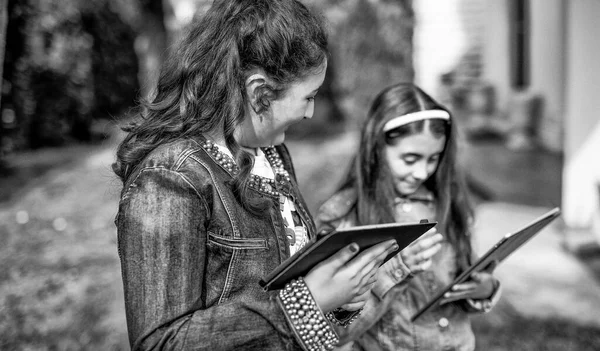 Dos Chicas Jóvenes Usando Tabletas Pie Parque Ciudad —  Fotos de Stock