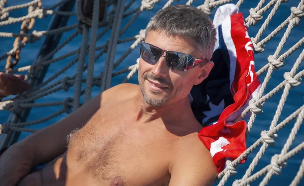 一个快乐的高加索人在船头的游轮网上放松的画像 — 图库照片