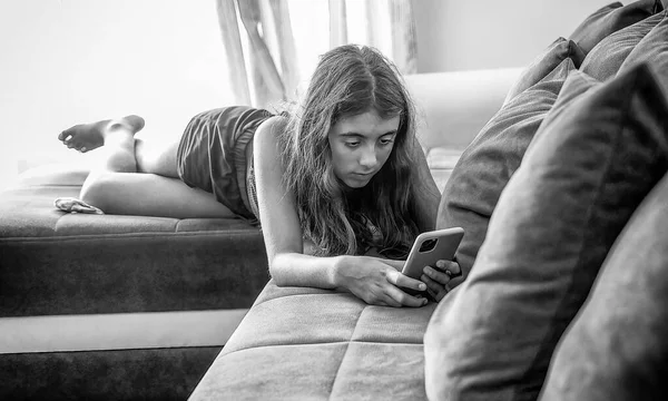 Молодая Девушка Отдыхает Диване Используя Смартфон Дома — стоковое фото
