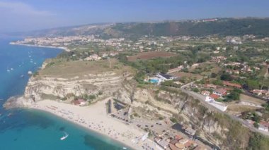 Plaj şemsiyeleriyle Tropea sahilinin panoramik hava manzarası, Calabria, İtalya.