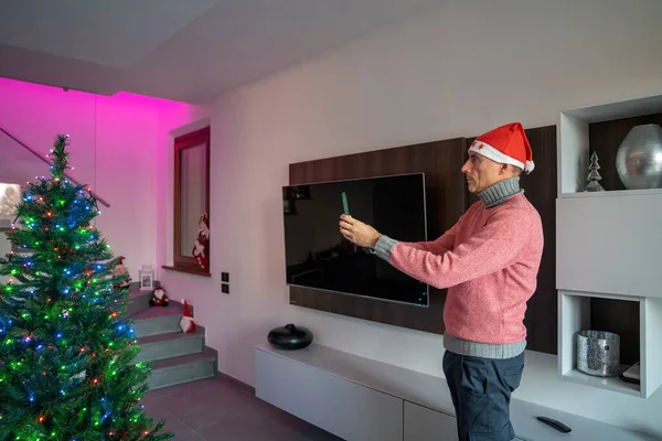 Muž Pomocí Chytré Domácí Aplikace Pro Zdobení Osvětlení Vánoční Strom — Stock fotografie
