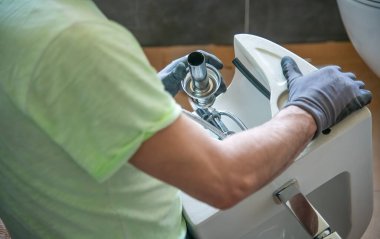 Tesisatçı yeni bir banyoya tuvalet kuruyor. Yeni bir ev konseptine geçiyoruz..