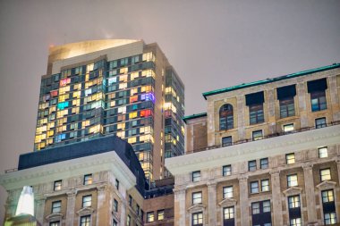 Çok katlı bir binada geceleri renkli pencereler.