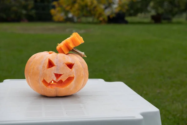 Decorated pumpkin for Halloween on a garden table