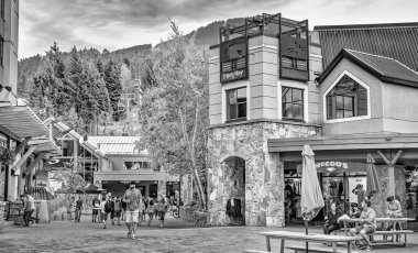 Whistler, Kanada - 12 Ağustos 2017: Güneşli bir günde şehir merkezini ziyaret eden turistler. Whistler ünlü bir turistik dağ beldesidir.