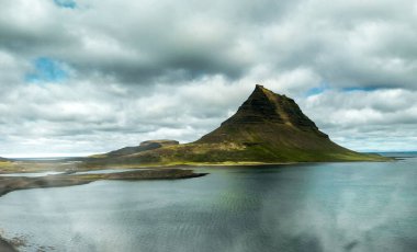 Arkasında göl ve okyanus olan ünlü İzlanda dağı Kirkjufell. Kirkjufell Dağı, yaz mevsiminde Snaefellsnes Yarımadası 'nda İHA bakış açısıyla.