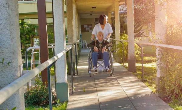 Asiatisk Kvinnlig Läkare Pratar Med Äldre Pensionerad Man Rullstolen Sjukhusgården — Stockfoto
