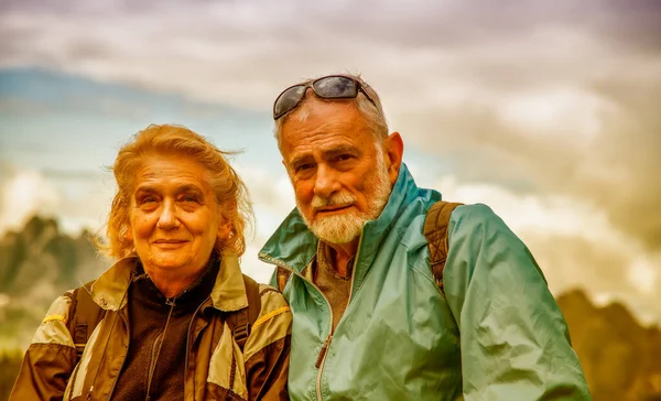 Elderly retired couple relaxing in the middle of a mountain trip