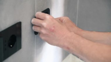 Elektrikçi konut elektrik sisteminin şalterleri ve prizleri üzerinde çalışıyor.