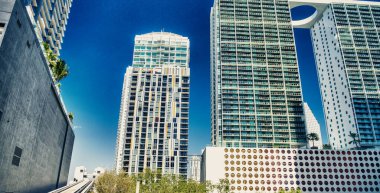 Miami Metrosu treni şehir merkezindeki gökdelenler arasında hızla ilerliyor..