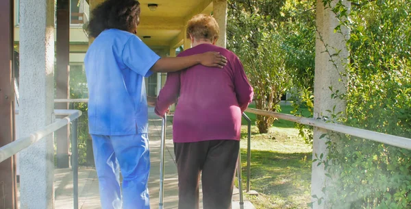 Afrikansk Kvinnlig Läkare Pratar Med Äldre Pensionerad Kvinna Med Käpp — Stockfoto