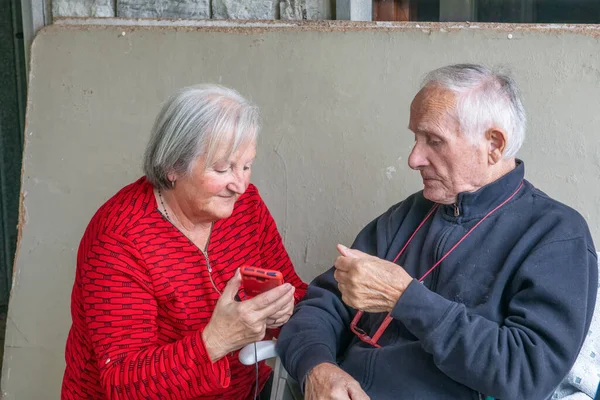 Elderly couple trying to figure out how to use a smarphone