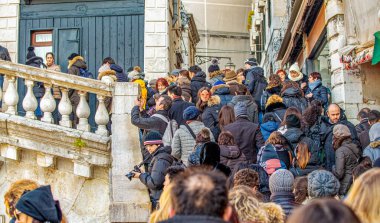 Venice, Italy - February 8, 2015: Crowd along Rialto Bridge during the carnival parade.