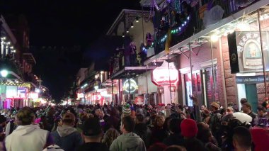 New Orleans, LA - February 9, 2016: Crowd of tourists and locals along the city streets at night for Mardi Gras event.