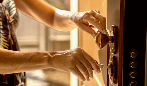 新しい家に移る 玄関のドアに新しいキーを挿入する女性の手 — ストック写真