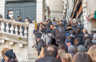 Venice, Italy - February 8, 2015: Crowd along Rialto Bridge during the carnival parade.