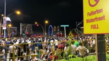 Singapur - 31 Aralık 2019: Geceleri Marina Körfezi bölgesinde kalabalık caddeler havai fişek gösterisi bekleyen insanlarla.
