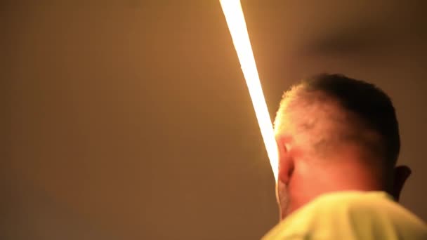 黄色の暖かい光 光のインストールでリードストリップ 男性インストーラ — ストック動画