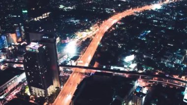 BANGKOK, THAILAND - 15 ARALIK 2019: Gece gökdelenler ve sokak trafiği ile şehrin gökyüzü manzarası.