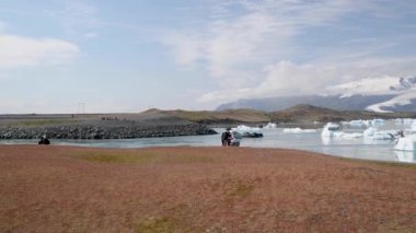 Floating icebergs in Jokulsarlon Lagoon on a sunny summer day, view from the car parking.