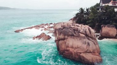 Amazing tropical beach Anse Patates with palm trees and granite boulders on La Digue Island, Seychelles.