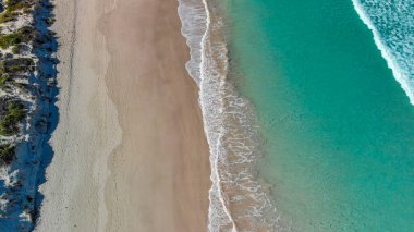 Above the ocean, aerial view at the waves and surface near shoreline - Drone viewpoint.