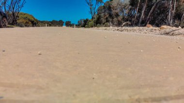 Kangaroo Island unpaved road along lake and trees, aerial view from drone - Australia.
