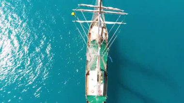 Sailing ship near the shoreline of a beautiful tropical island, aerial view.