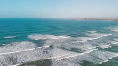 Aerial view of gentle waves along the beautiful shoreline.