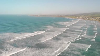 Aerial view of gentle waves along the beautiful shoreline.