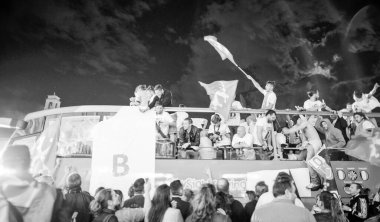 PISA, ITALY - JUNE 15TH, 2016: Local fans celebrate the soccer team's promotion. Celebrations in the night with smoke bombs and an open bus.