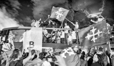 PISA, ITALY - JUNE 15TH, 2016: Local fans celebrate the soccer team's promotion. Celebrations in the night with smoke bombs and an open bus.