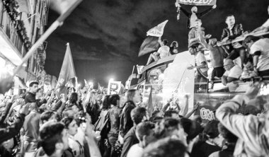PISA, ITALY - JUNE 15TH, 2016: Local fans celebrate the soccer team's promotion. Celebrations in the night with smoke bombs and an open bus.