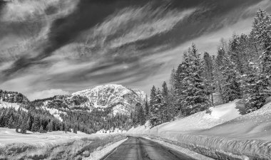 Road through a beautiful snowy valley, dolomite mountains in winter season.