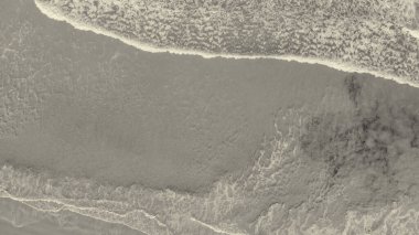 Above the ocean, aerial view at the waves and surface near shoreline - Drone viewpoint.