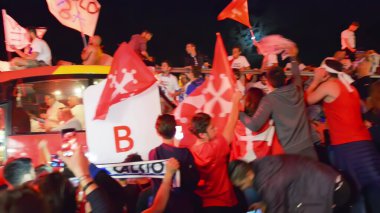 PISA, ITALY - JUNE 15TH, 2016: Local fans celebrate the soccer team's promotion. Celebrations in the night with smoke bombs and an open bus.