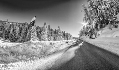 Road through a beautiful snowy valley, dolomite mountains in winter season.