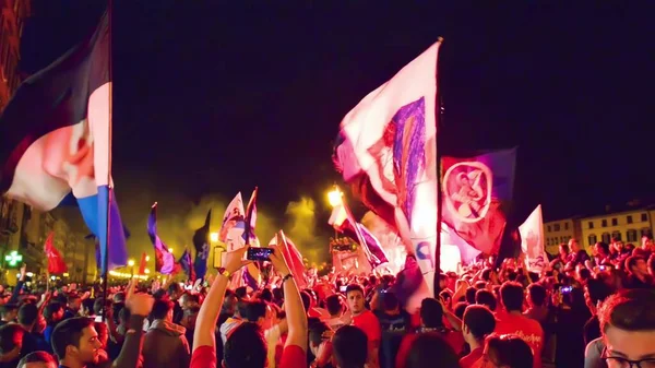PISA, ITALY - JUNE 15TH, 2016: Local fans celebrate the soccer team's promotion. Celebrations in the night with smoke bombs and an open bus.
