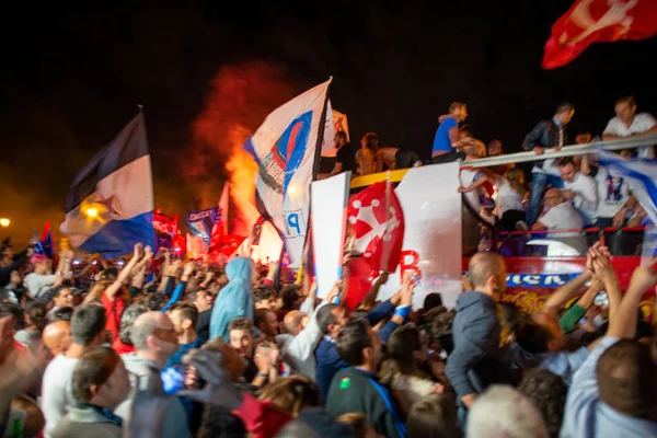 PISA, ITALY - JUNE 15TH, 2016: Local fans celebrate the soccer team's promotion. Celebrations in the night with smoke bombs and an open bus.