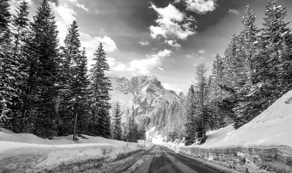 Road through a beautiful snowy valley, dolomite mountains in winter season.