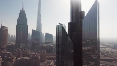 Downtown Dubai, going down from the sky. Aerial view of city centre and skyscrapers on a sunny day.