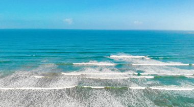 Aerial view of gentle waves along the beautiful shoreline.